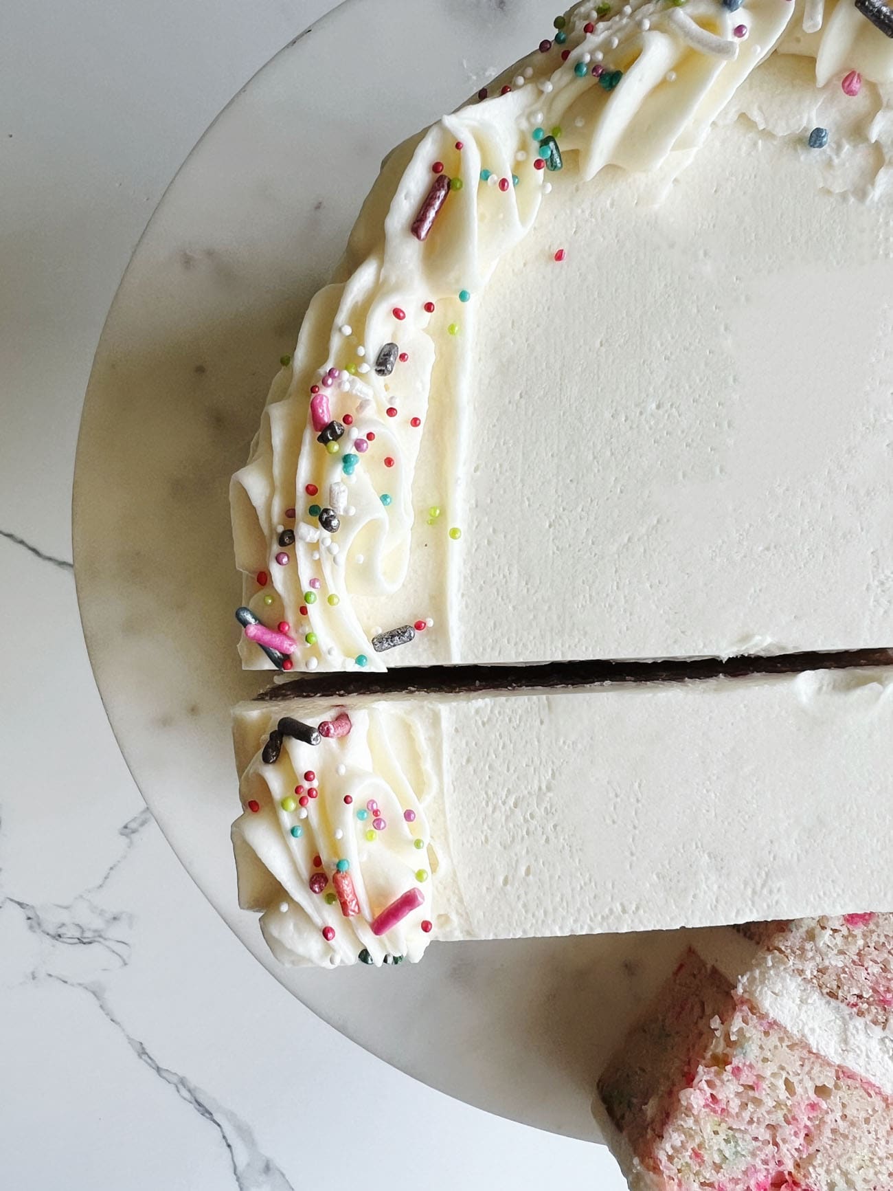 white cake with sprinkles on cake stand