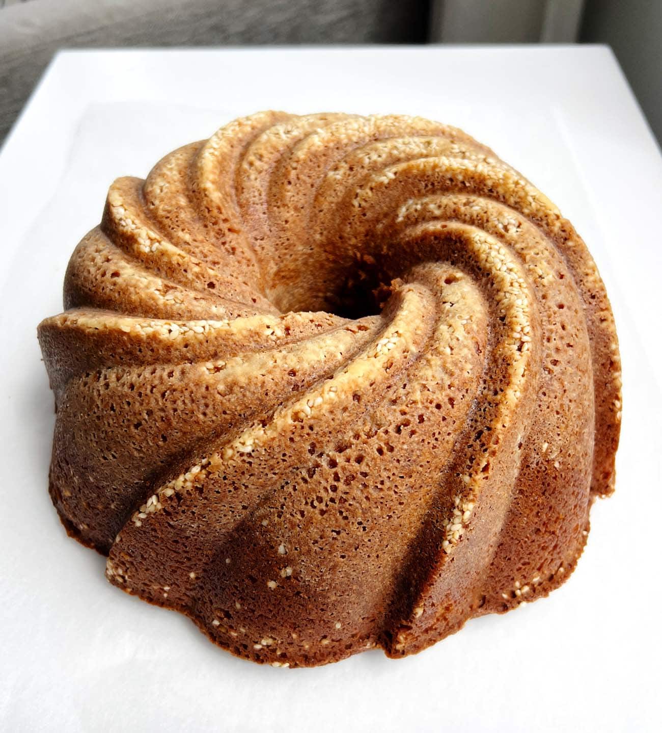 toasted sesame bundt cake on white surface