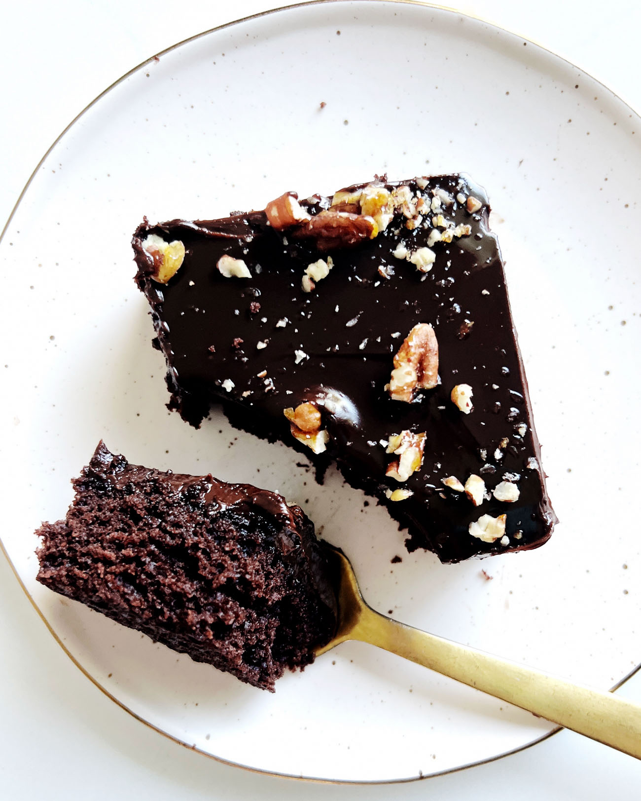 chocolate sheet cake on white plate with gold spoon