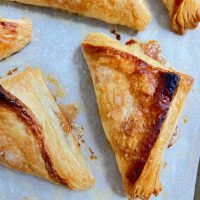 flaky puff pastry apple turnovers on parchment