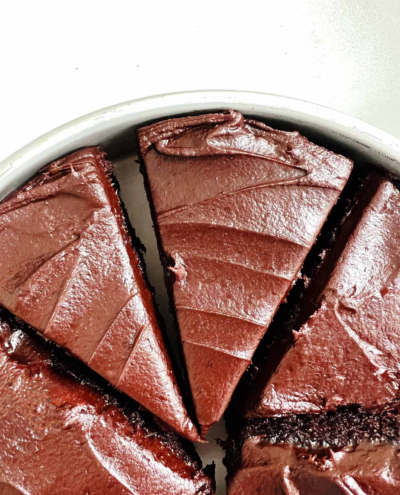 chocolate cake cut into slices, in round pan